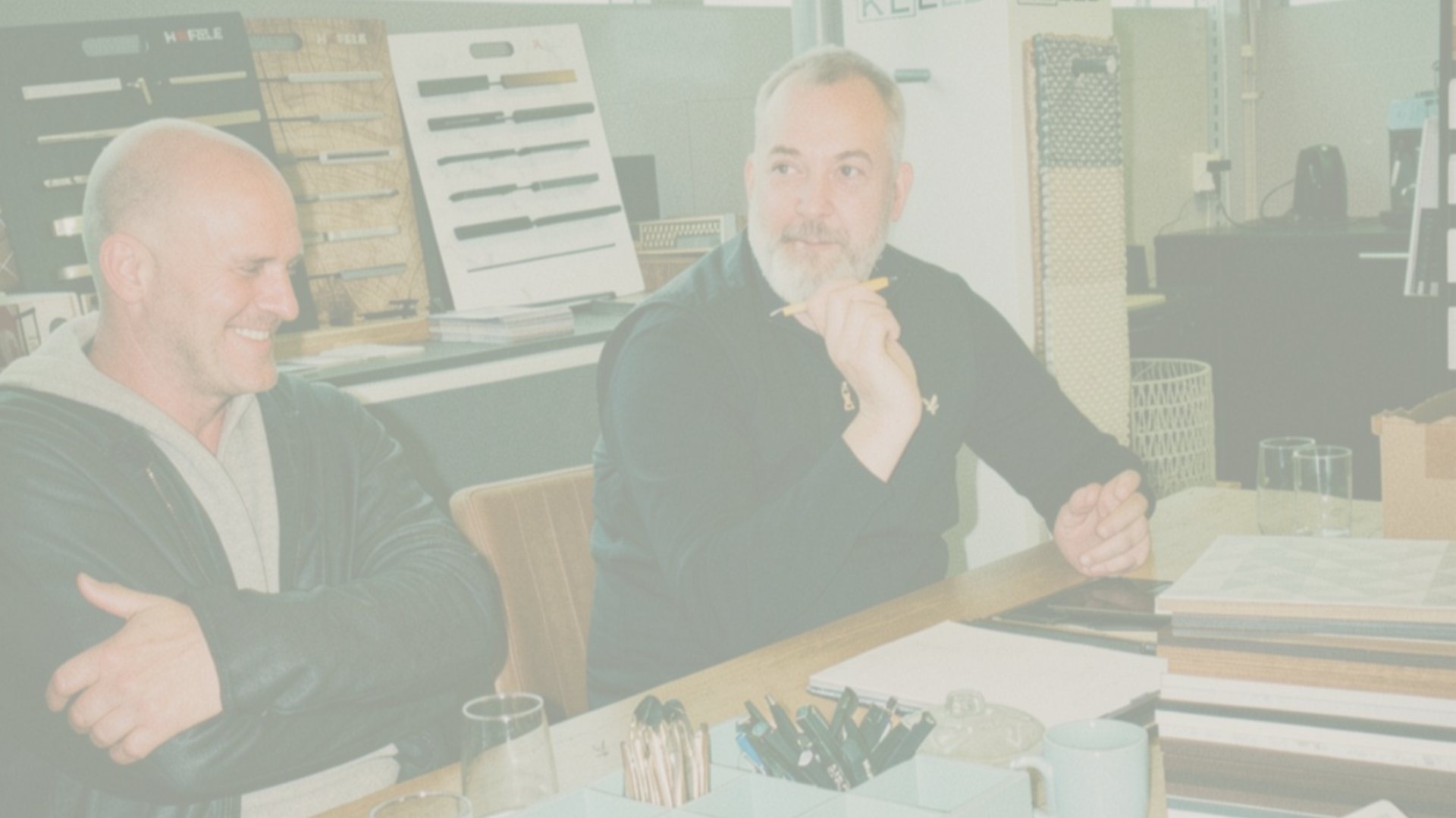Two members of the design team at a table in the showroom, among material samples