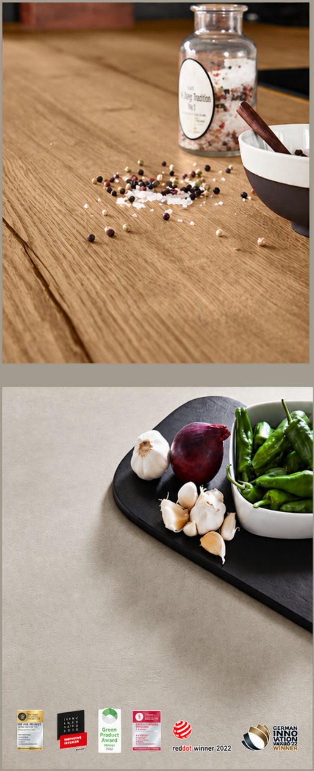 An oak effect worktop scattered with salt and pepper, and a stone effect worktop with garlic, chillies and an onion, with its design awards